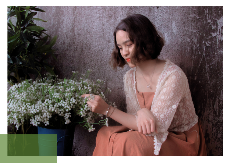 Eine Frau zeigt auf eine blühende Pflanze – ein Symbol für den Erhalt von Pflanzenvielfalt im Kontext von SDG 15.