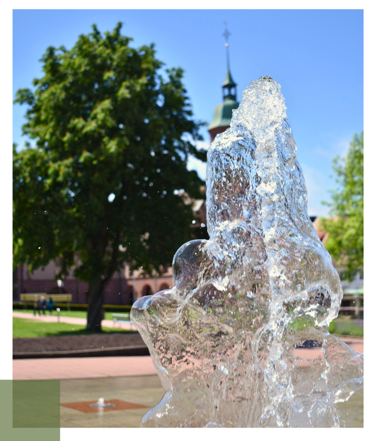 ruhiger Park mit Wasserfontäne im Vordergrund