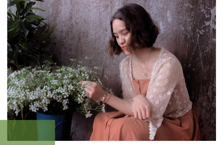 A woman points at a flowering plant – symbolizing the importance of preserving plant diversity under SDG 15.